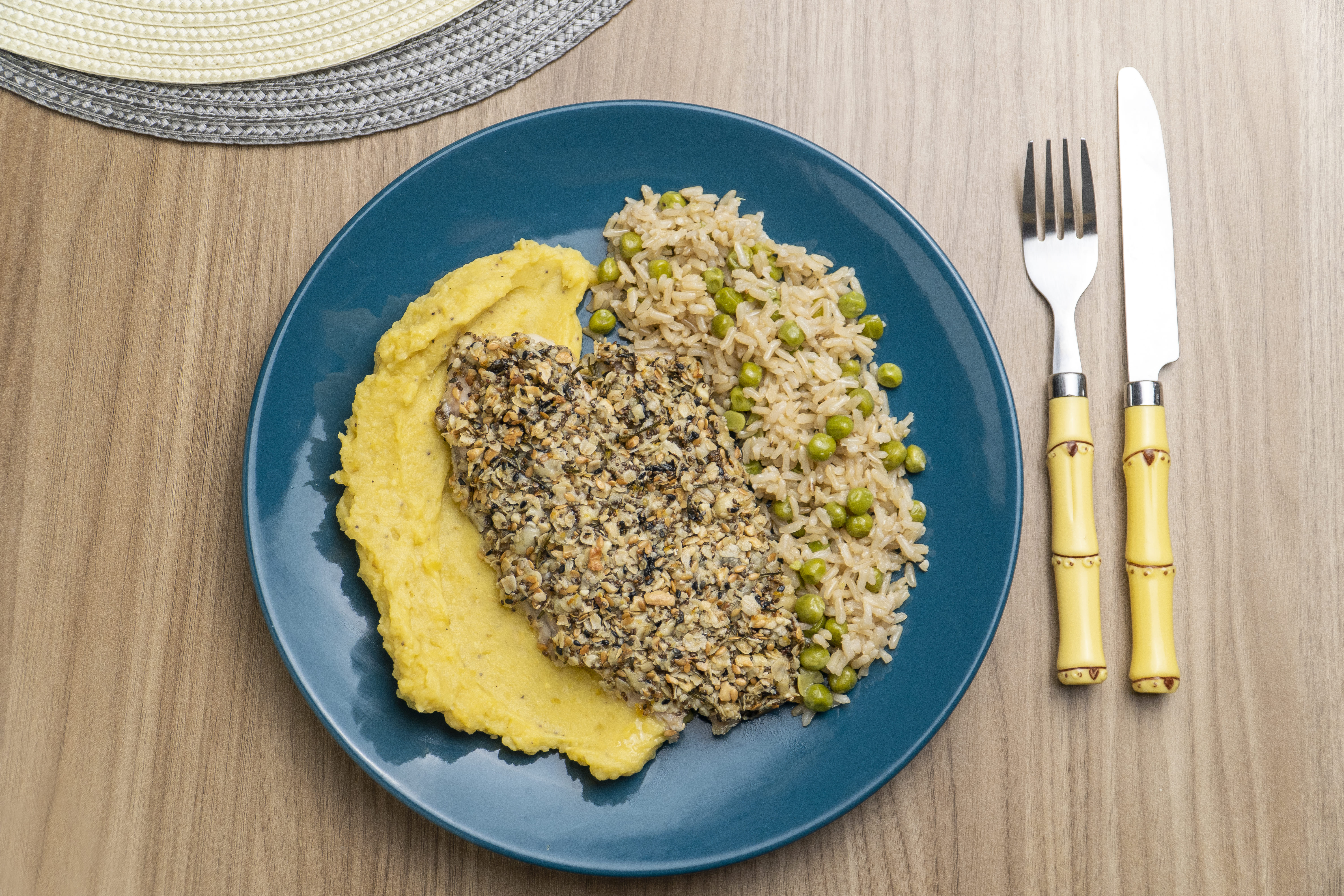 Tilápia em crosta cítrica de castanhas com purê de banana da terra e arroz integral com ervilha